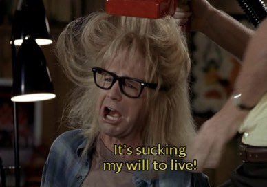 A still image from Wayne's World, of Garth Algar being subjected to the Suck Cut hair cutting device